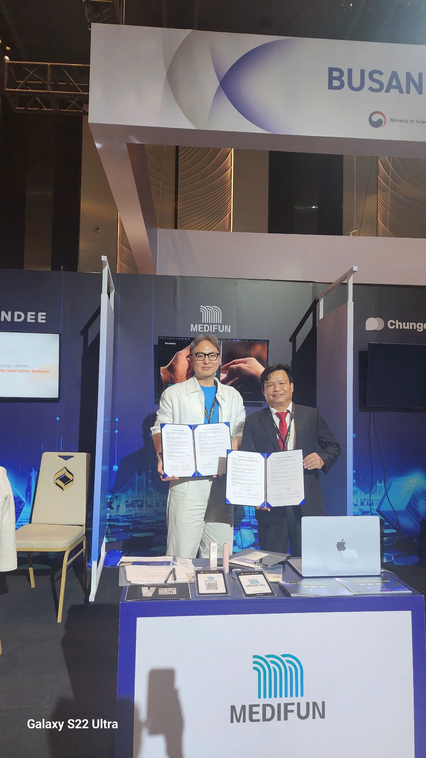 Đại diện TH và đối tác cầm văn bản đã ký tại Busan Blockchain Pavilion